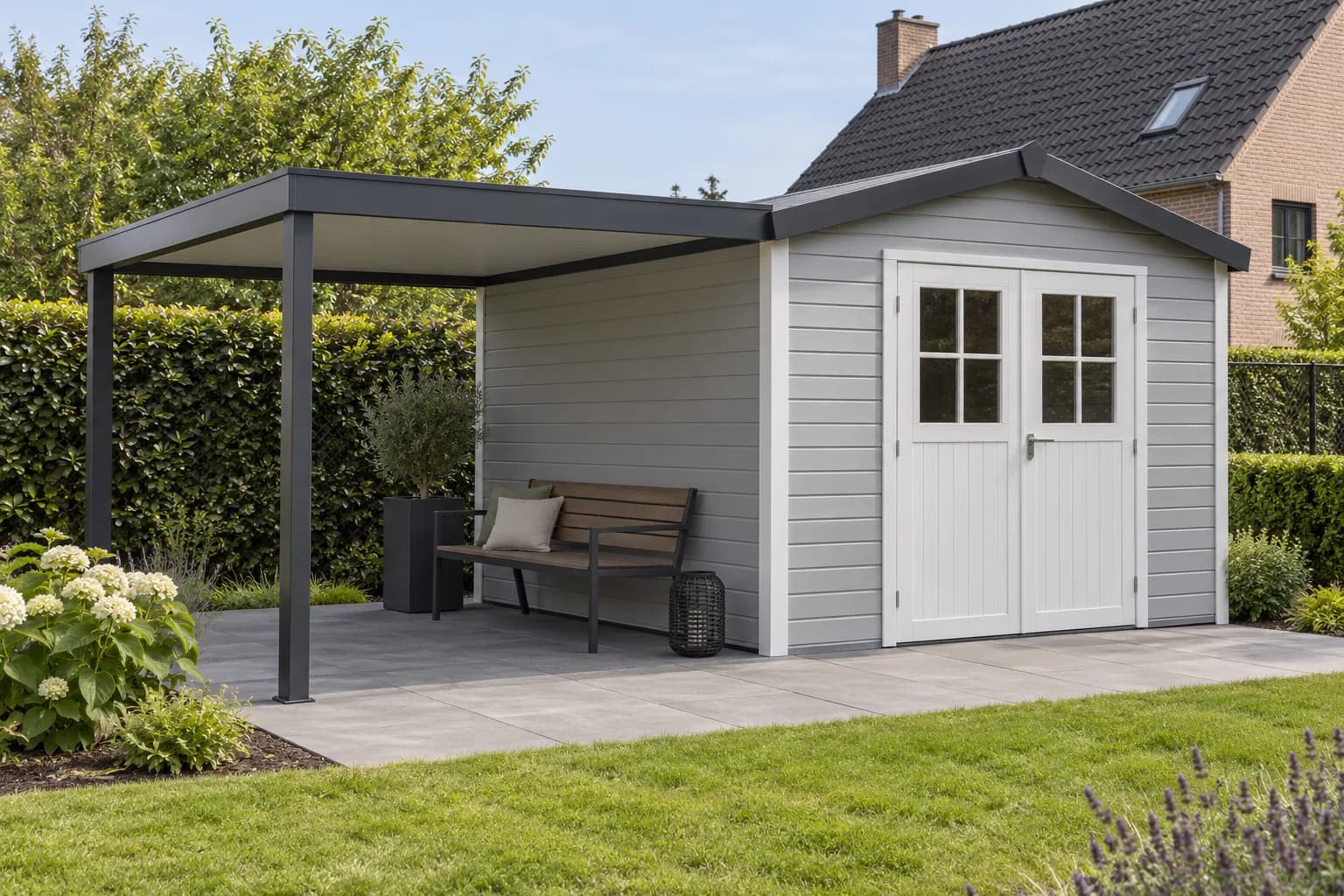 Abri à bardage PVC gris clair et portes blanches avec banc sous un auvent à ossature sombre