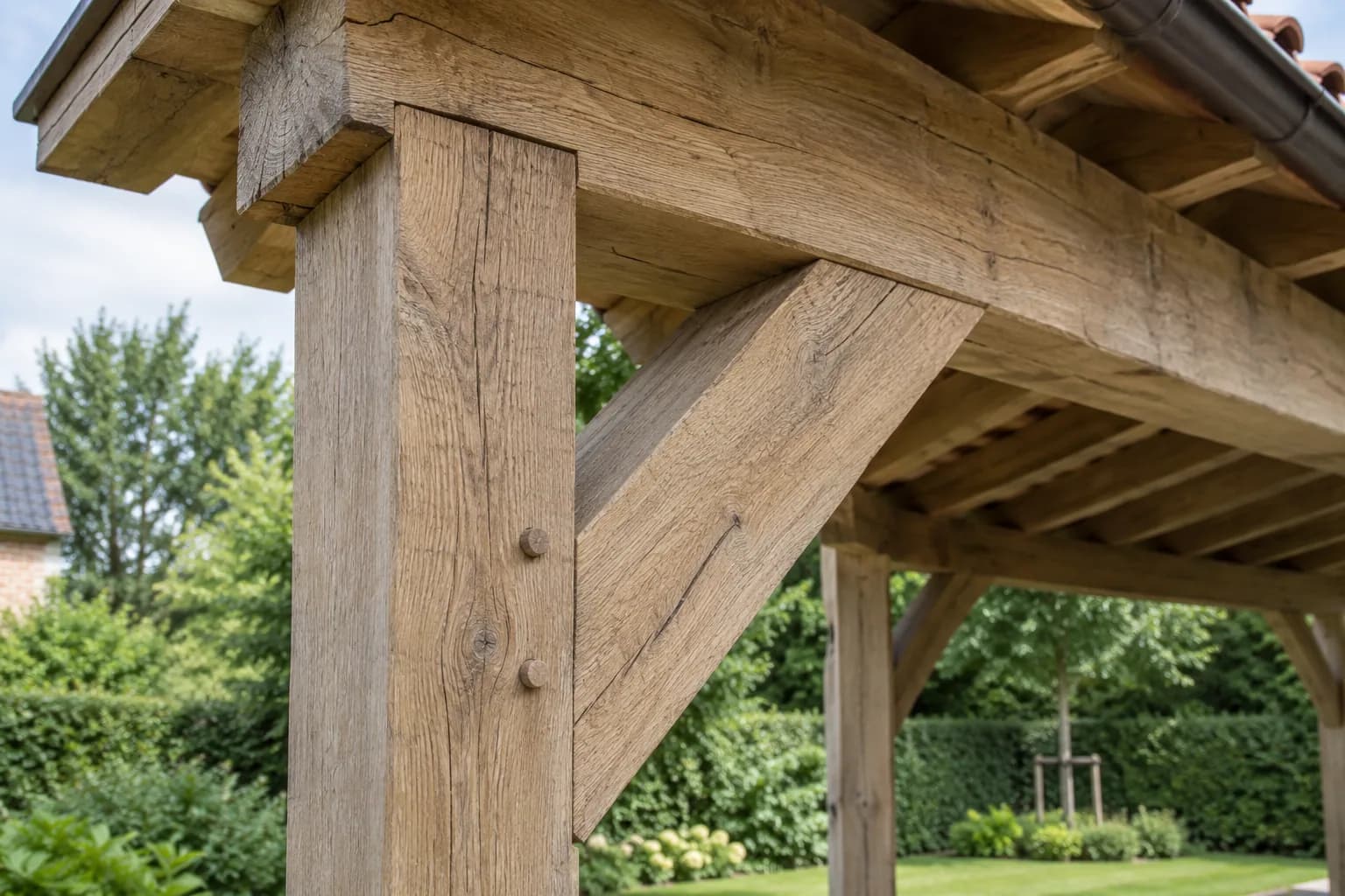 Gros plan sur un poteau et une jambe de force en chêne avec chevilles en bois sous la toiture.