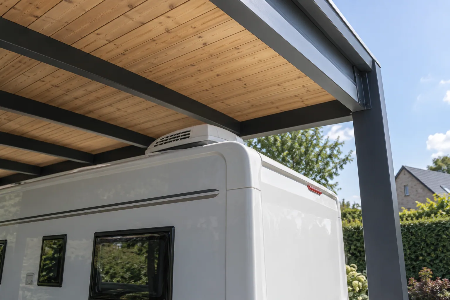 Vrije ruimte tussen de dakunit van een camper en de balken van de carport.