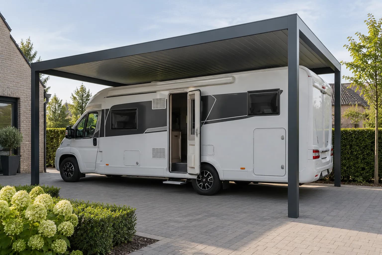 Camper met geopende zijdeur en vrije instapruimte onder een hoge metalen carport.