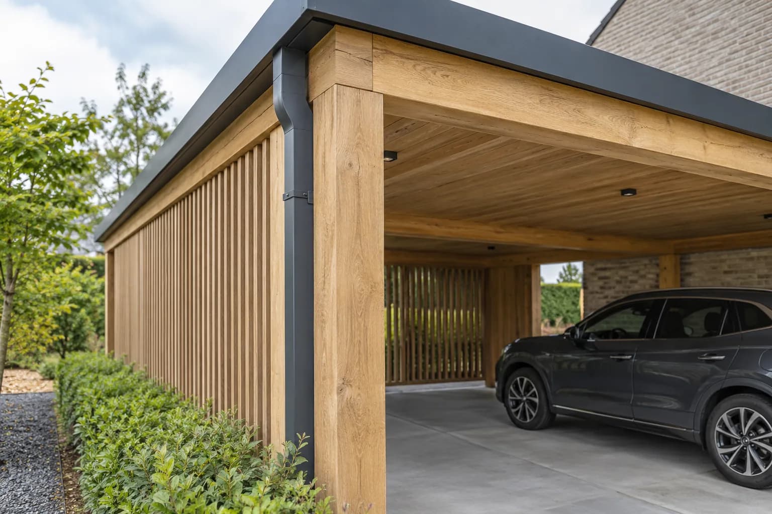 Hoekverbinding van een houten carport met aluminium dakrand en afvoer