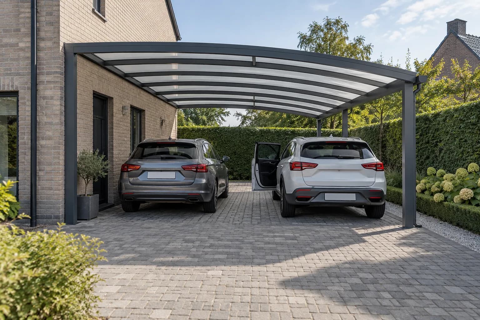 Twee auto's met ruimte tussen de voertuigen en een geopende deur onder een dubbele carport.