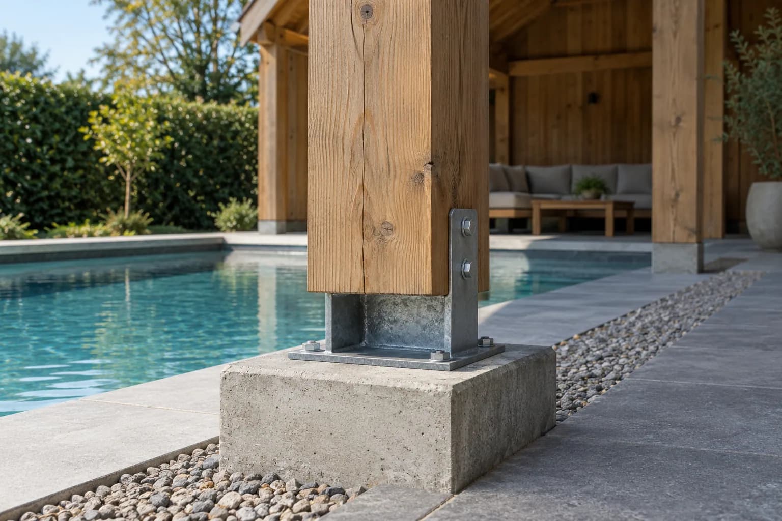 Houten poolhousepaal in een verzinkte stalen voet op een betonnen sokkel langs een grindstrook