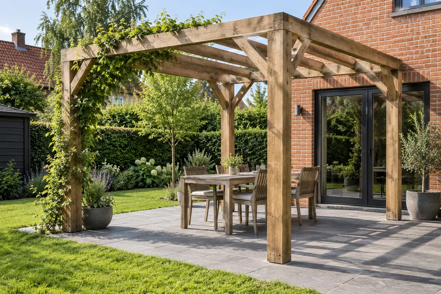 Open houten pergola met klimplant en eettafel op een terras naast een bakstenen woning.