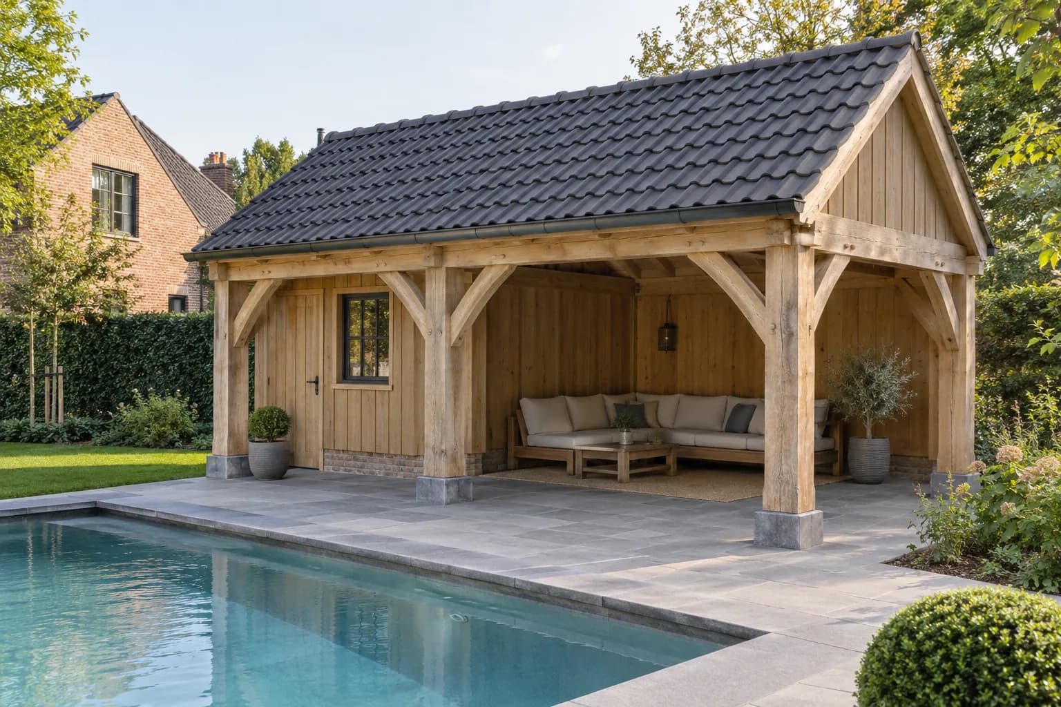 Eiken poolhouse met zware gebinten, schoren en een pannenzadeldak naast het zwembad