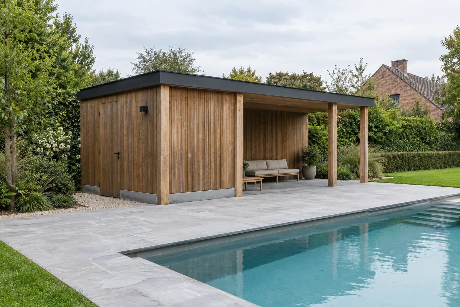 Houten poolhouse met verticale planken, gesloten berging en overdekt zitgedeelte naast een zwembad