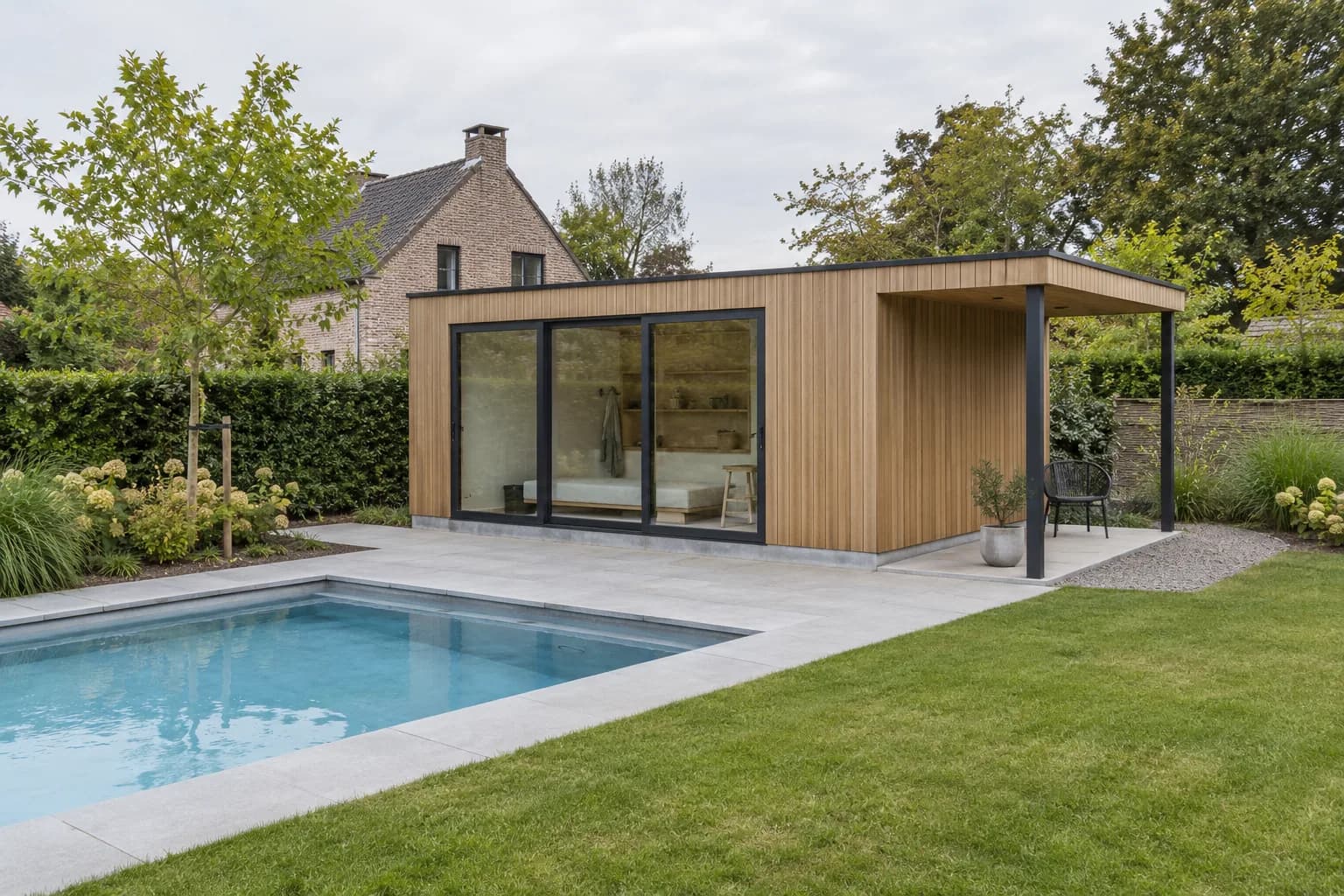 Compact poolhouse met houten gevel, glazen schuifpui en kleine zijluifel op een betonnen plint