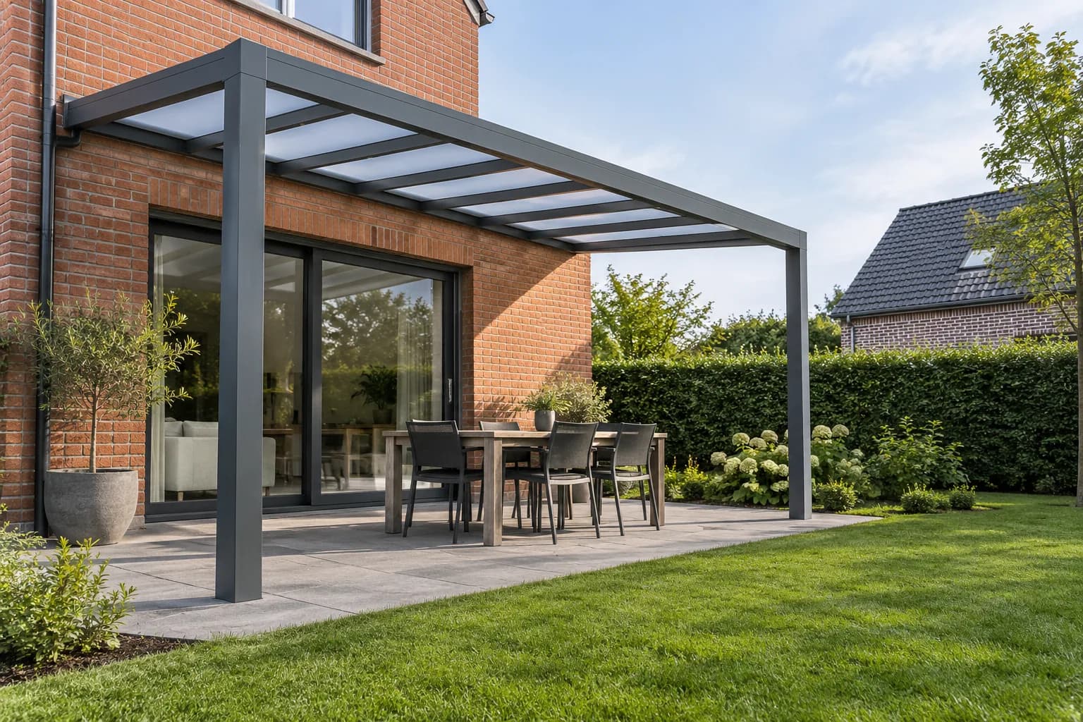 Aluminium terrasoverkapping met lichtdoorlatend dak en open zijkanten aan een bakstenen woning.