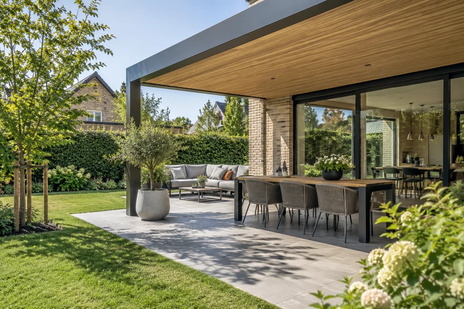 Terrasoverkapping met een eettafel en zithoek aan de tuin