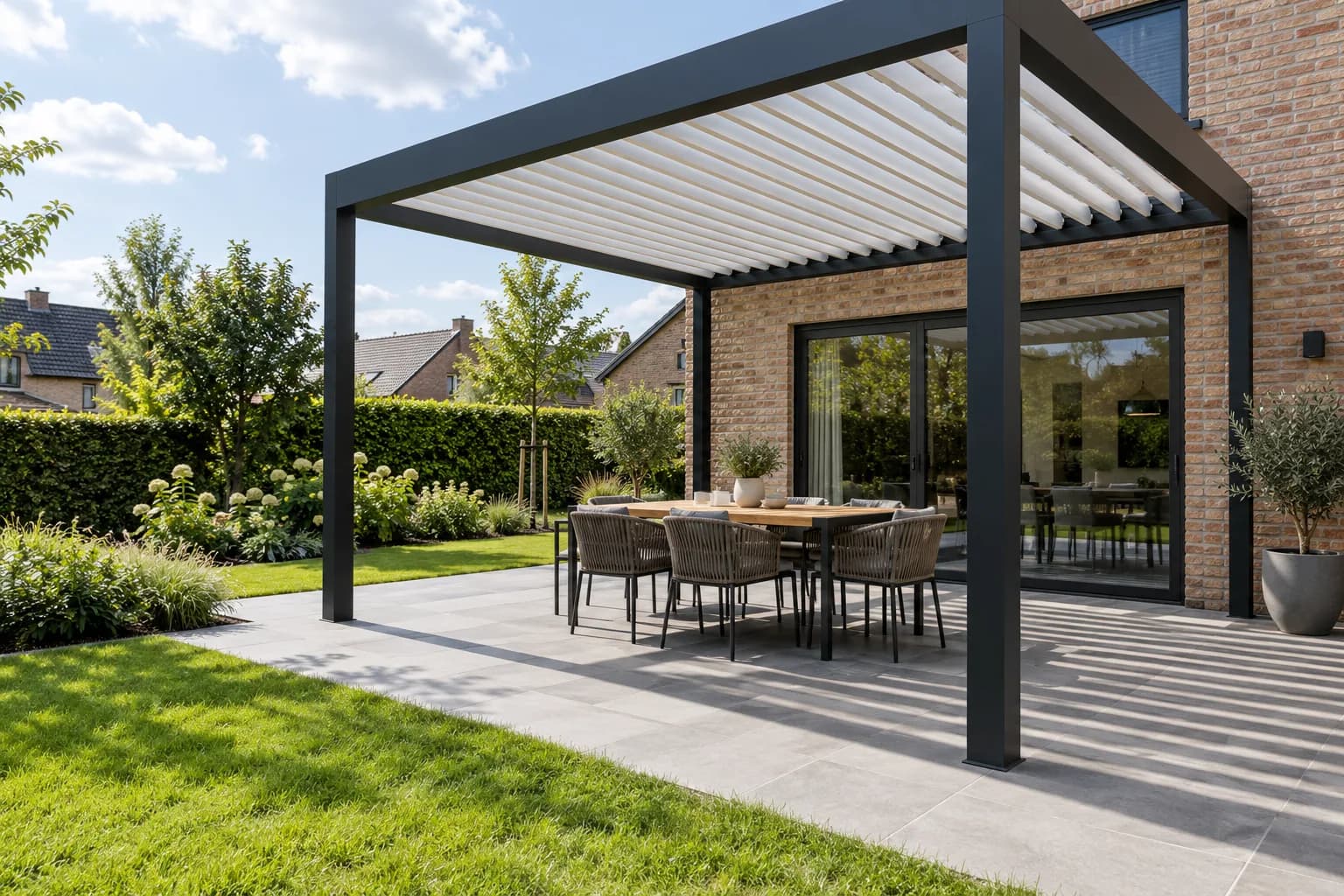 Terrasoverkapping met gekantelde lamellen en een eettafel naast de woning.