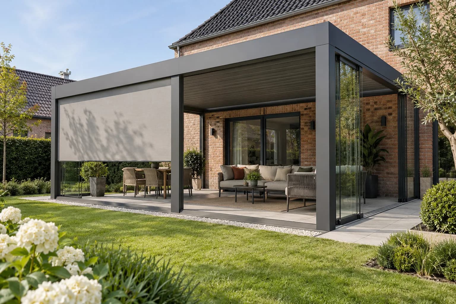 Lamellenoverkapping met glazen schuifwand, zijscreen en een ingerichte zithoek.