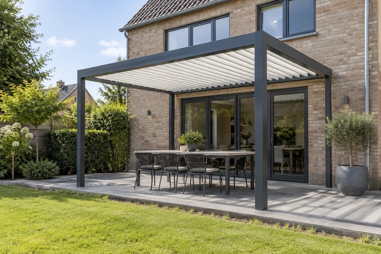 Compact lamellendak met vier staanders, open zijden en een eettafel op het terras.