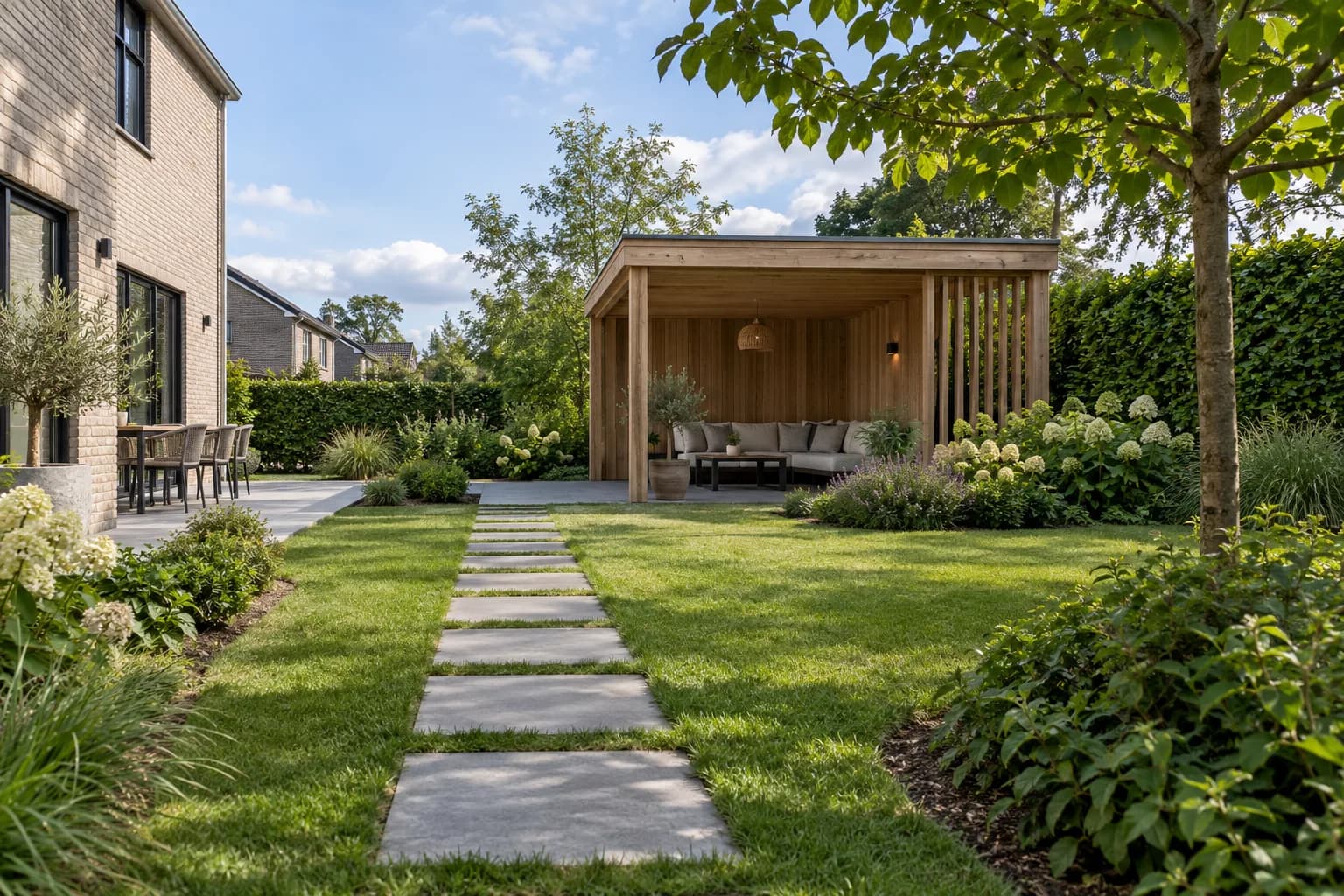 Tuinpad naar een vrijstaande houten overkapping met een open zithoek.