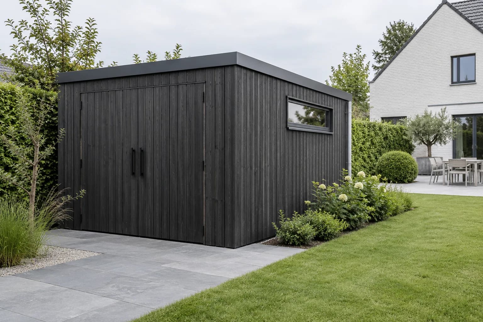 Moderne donkere tuinberging met verticale houten gevel, dubbele deur, plat dak en hoog zijraam.