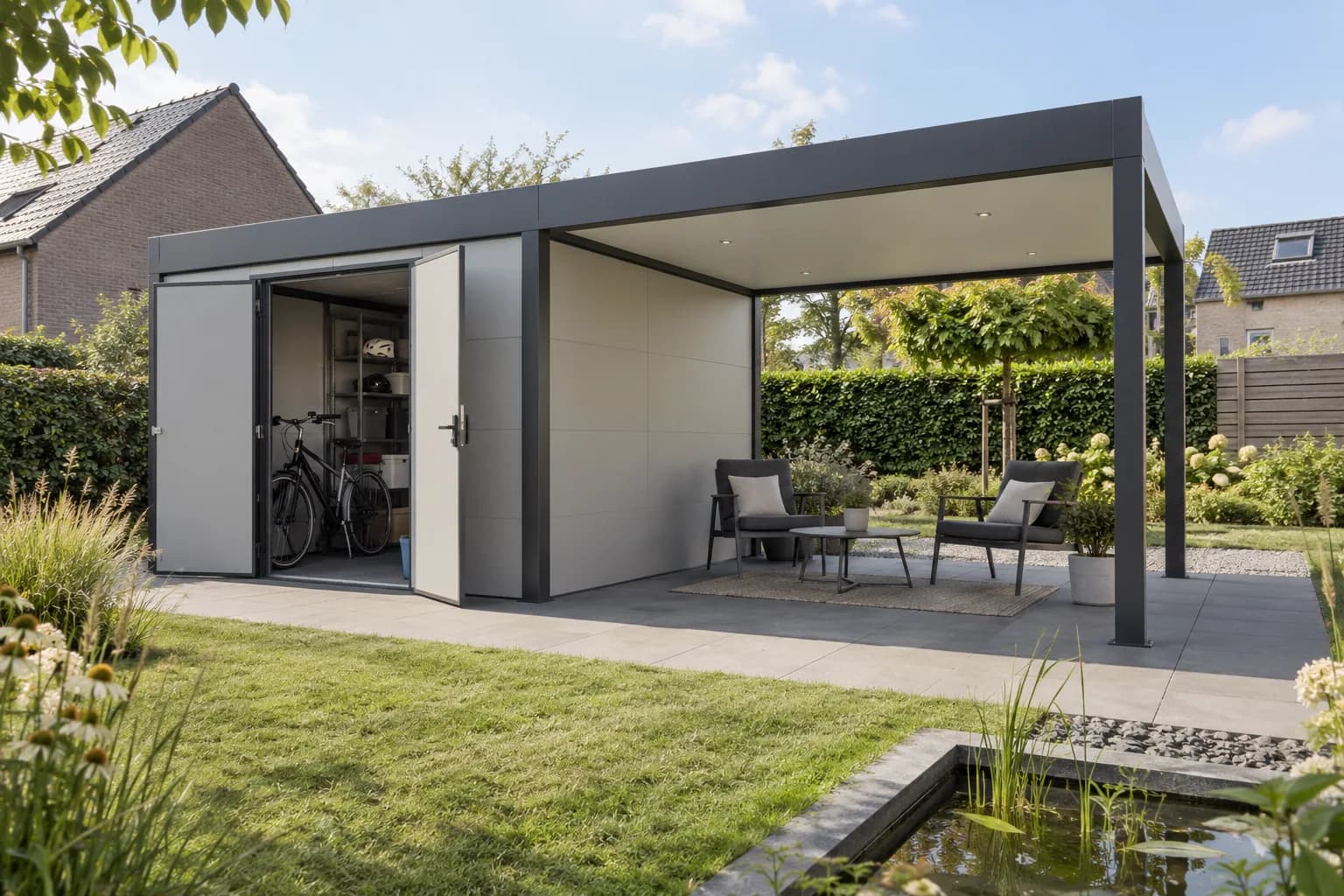 Overdekte zithoek naast een aluminium tuinberging met een fiets achter de open deuren.