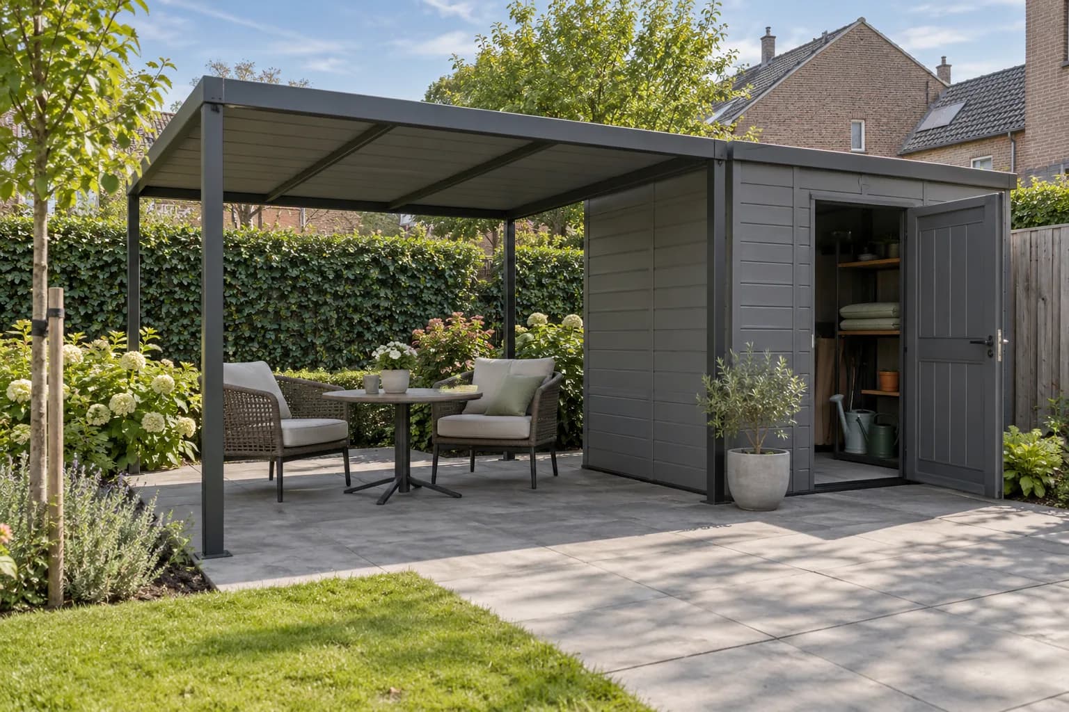 Zitstoelen onder een losstaande overkapping naast een kunststof berging met tuingerief.