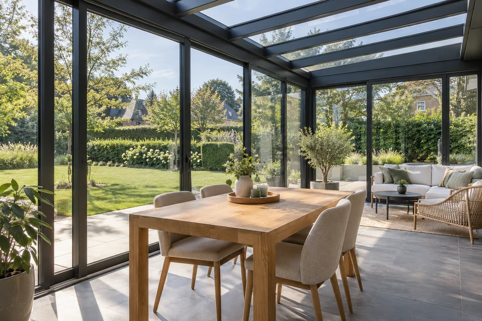 Binnenzicht van een aluminium veranda met eettafel en zichtbare dak- en raamprofielen.